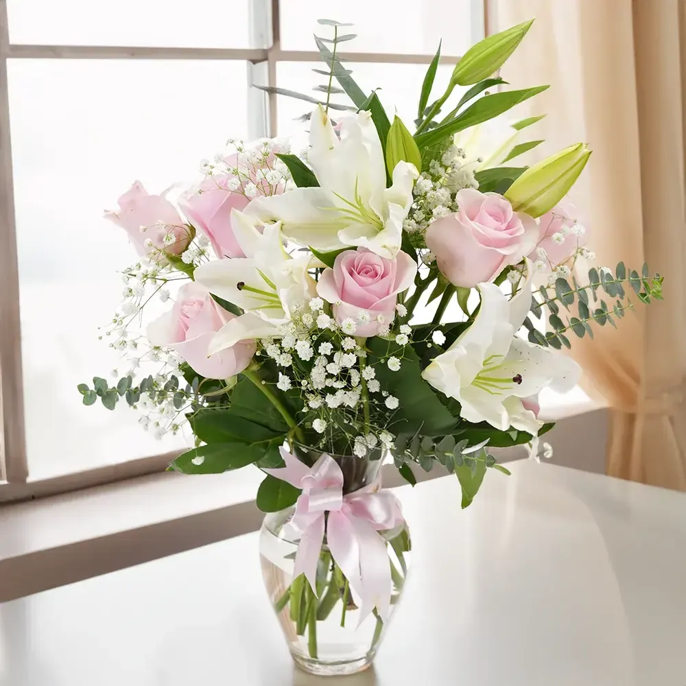 pink roses and white lilies with gypsophilia in glass vase