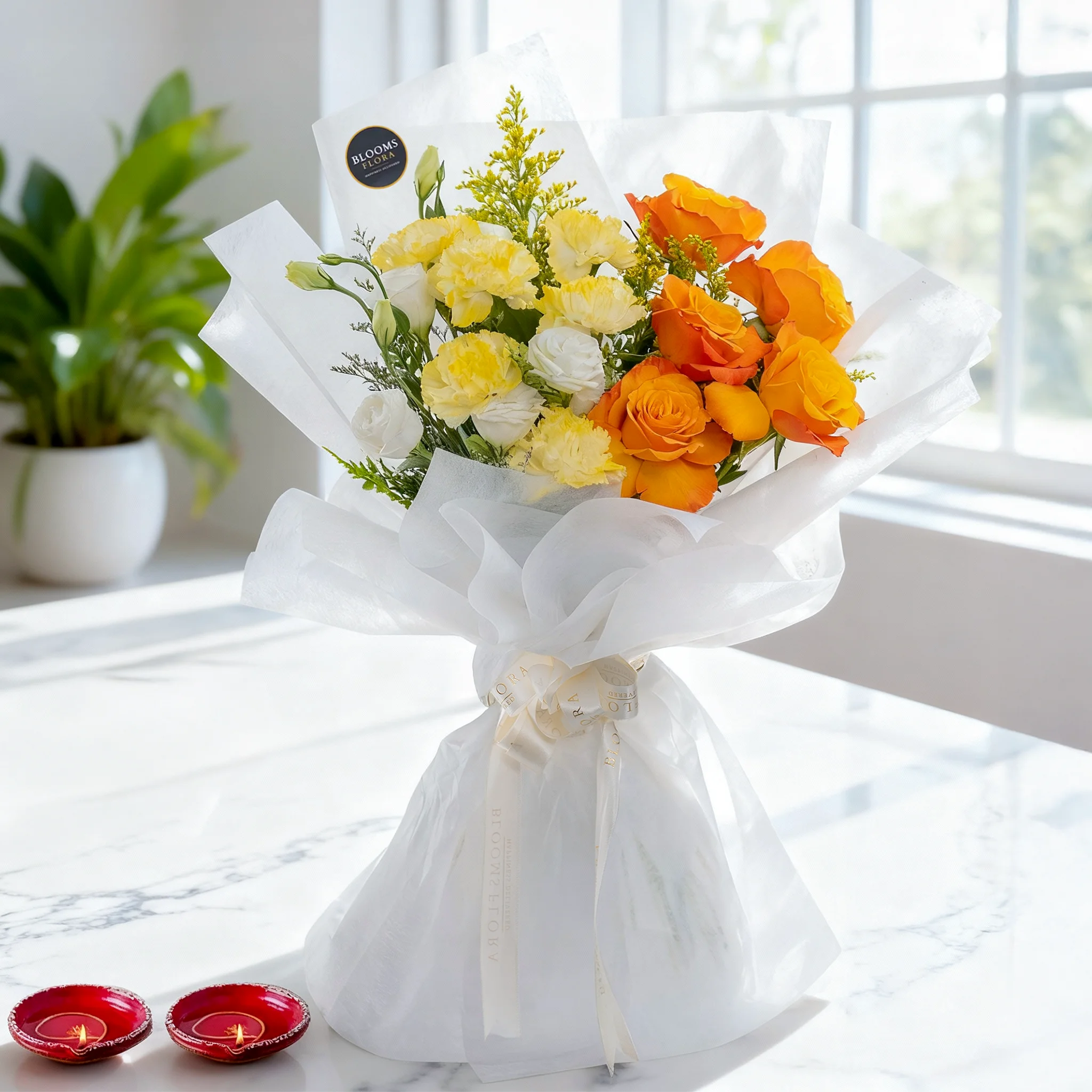 Bouquet of 6 White Roses, 5 Orange Roses & 6 Yellow Carnations with fillers in white wrapping along with 2 Diyas