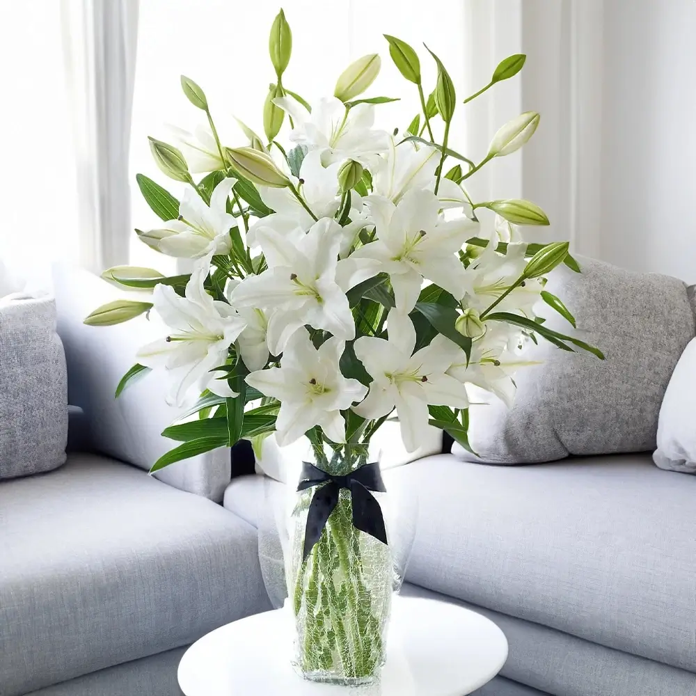 4 white lilies in a glass vase